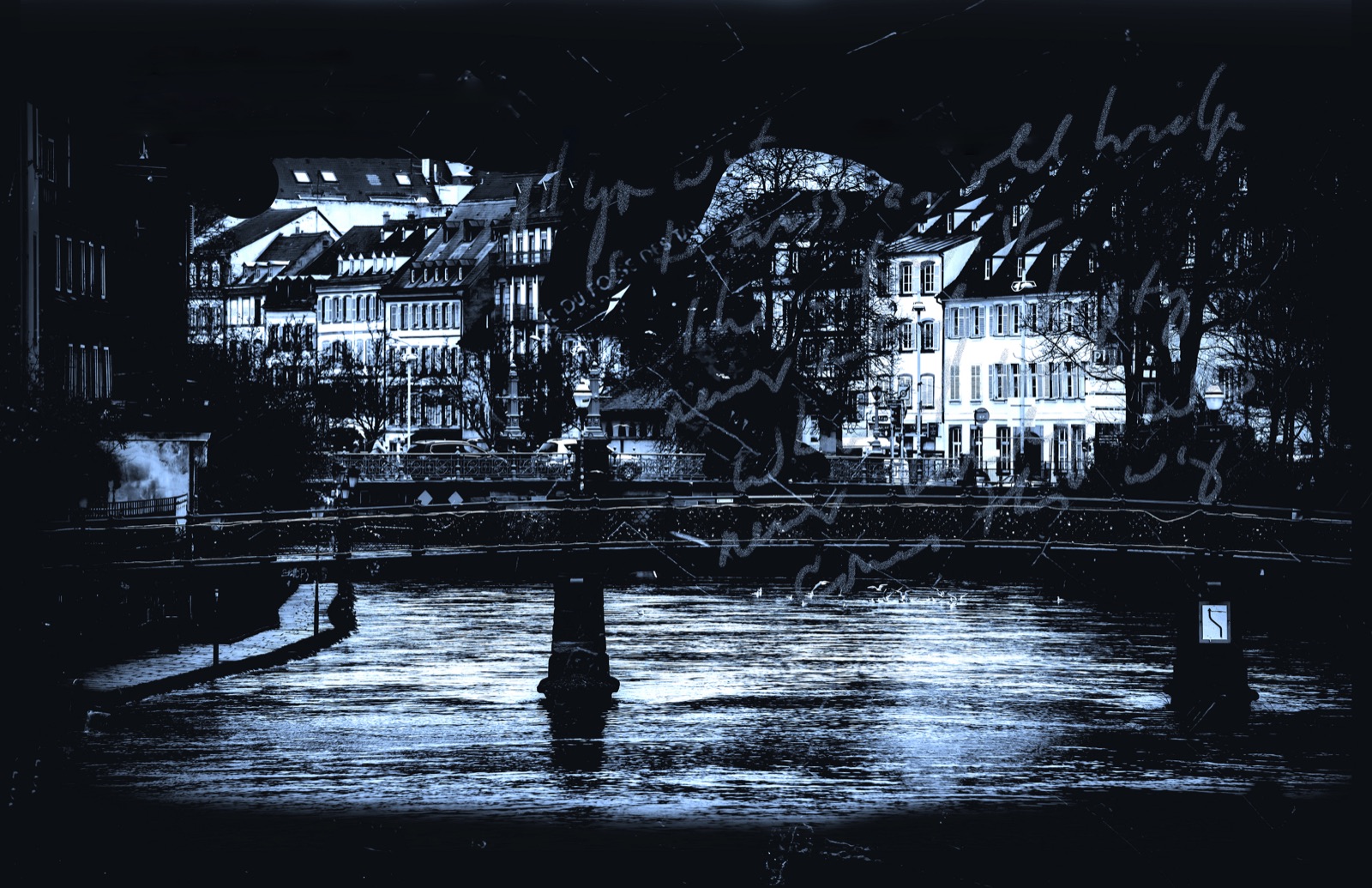 A footbridge over the Ill with houses behind, handwriting across the image